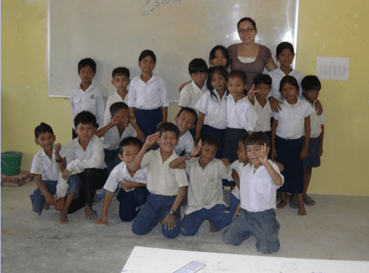 A group of children in white shirts and blue pants.