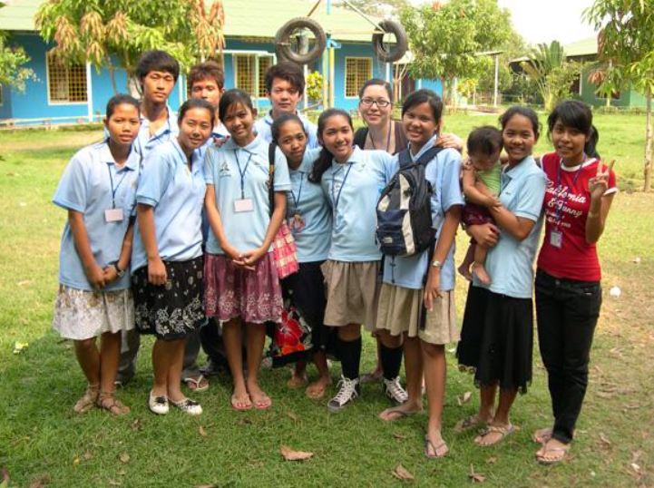 A group of people standing in the grass.