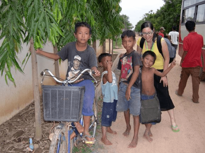 A group of children standing next to a bicycle.
