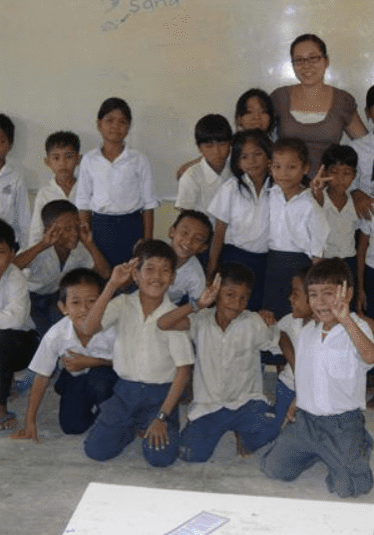 A group of children in white shirts and blue pants.